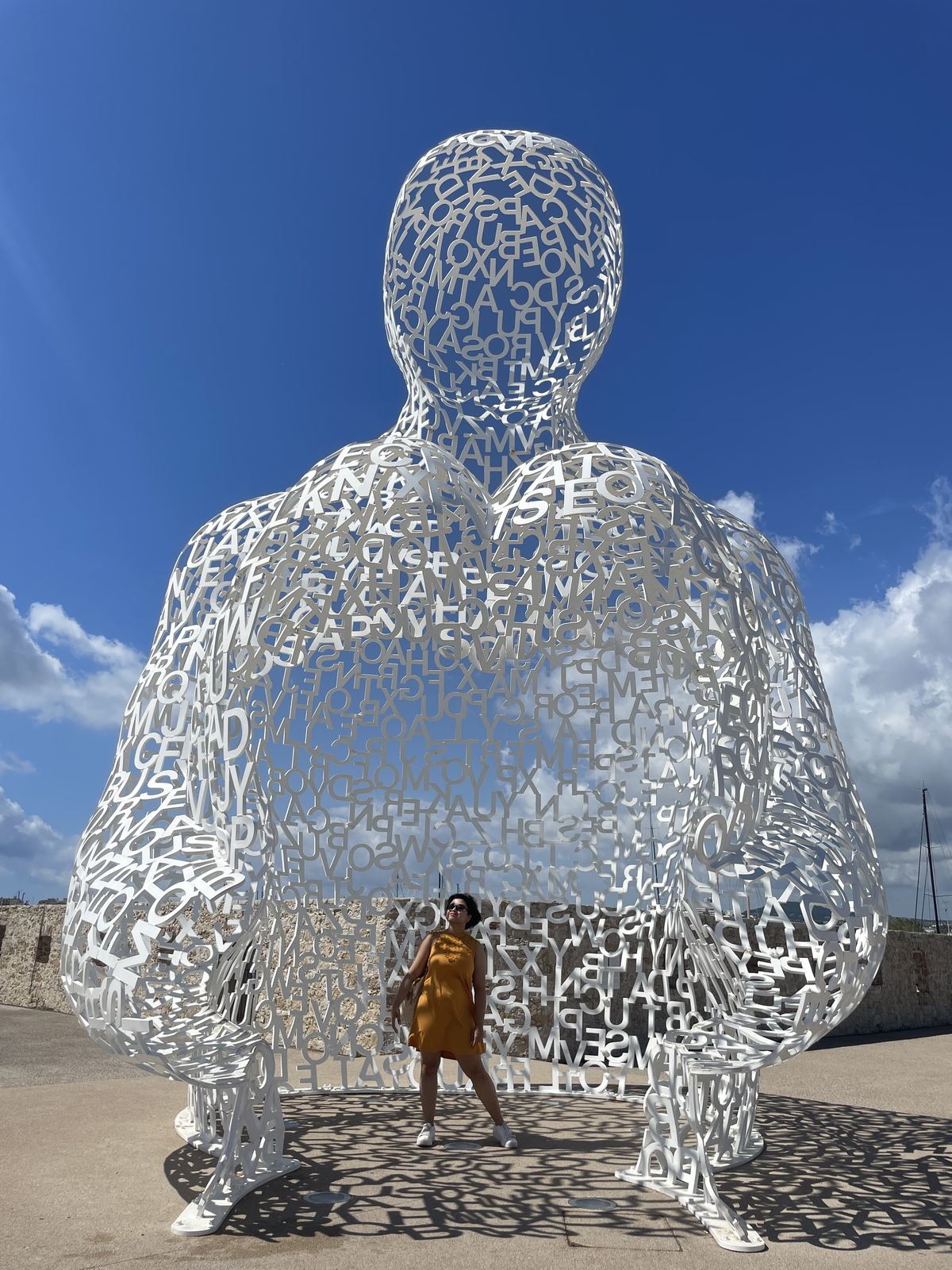 Sucheta standing inside a large white perforated letter sculpture by Jaume Plensa outside the Picasso Museum